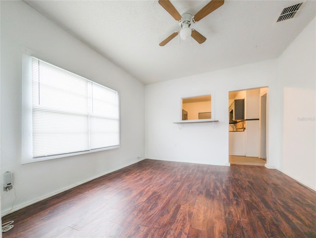 unfurnished living room featuring ceiling fan and dark hardwood / wood-style flooring