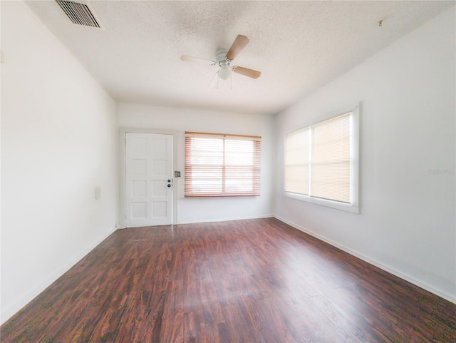 unfurnished room with ceiling fan, dark hardwood / wood-style flooring, and a textured ceiling