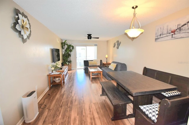 dining room with ceiling fan, a textured ceiling, and hardwood / wood-style floors