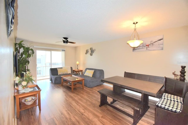 living room featuring ceiling fan, a textured ceiling, and hardwood / wood-style floors