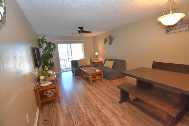 living room featuring a textured ceiling, ceiling fan, and hardwood / wood-style floors