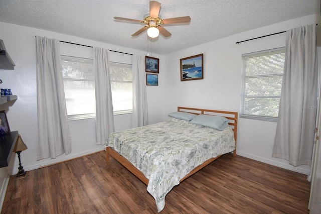 bedroom featuring dark wood-type flooring, ceiling fan, and a textured ceiling