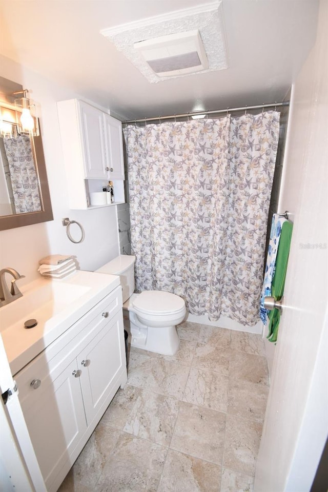 bathroom featuring toilet, vanity, and walk in shower