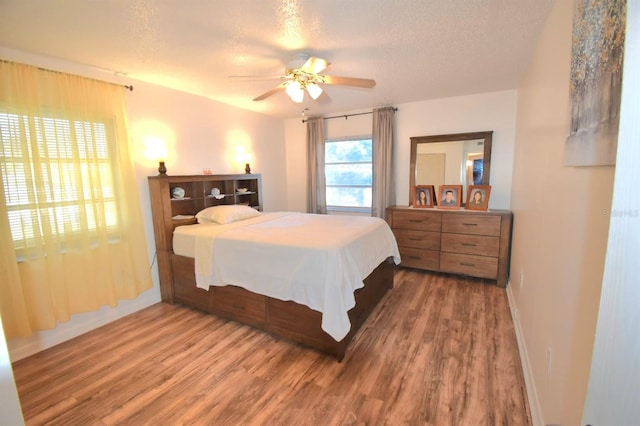 bedroom featuring a textured ceiling, ceiling fan, and hardwood / wood-style flooring