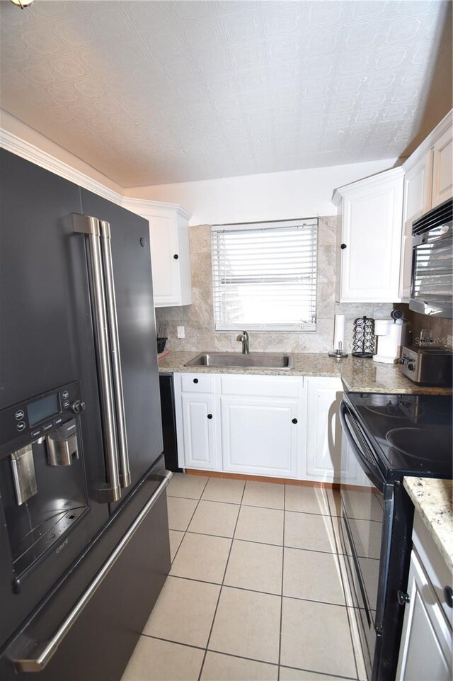 207 S Mcmullen Booth Rd Unit 198, Clearwater, FL 33759 - kitchen featuring tasteful backsplash, a sink, light tile patterned floors, black appliances, and white cabinetry