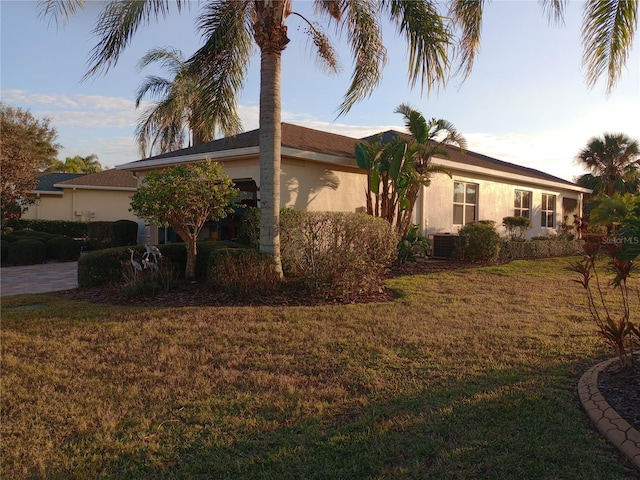 view of property exterior with a lawn and central air condition unit