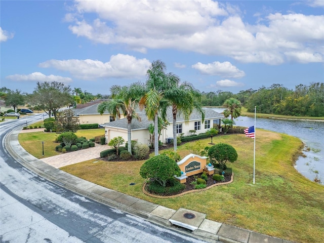 view of front facade featuring a water view and a front lawn