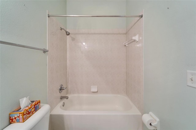 bathroom featuring toilet and tiled shower / bath combo