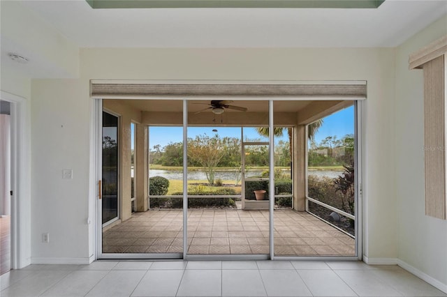 unfurnished sunroom featuring a water view and ceiling fan