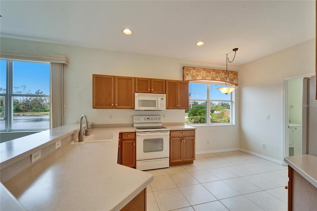 kitchen featuring hanging light fixtures, light tile patterned flooring, sink, and white appliances