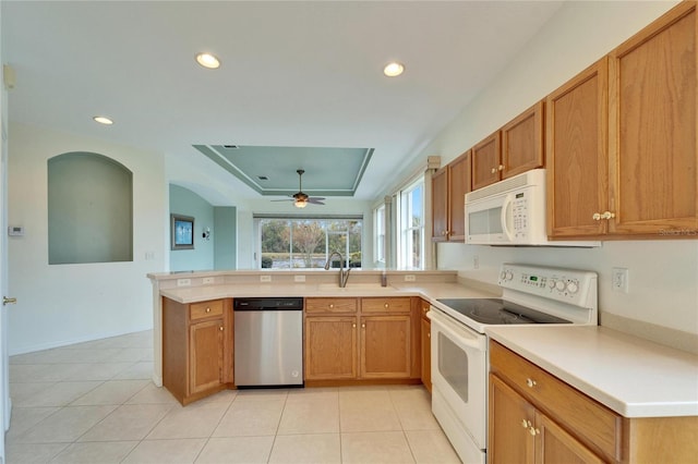 kitchen with sink, white appliances, light tile patterned floors, and kitchen peninsula