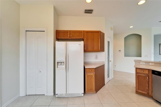 kitchen featuring dishwasher, white fridge with ice dispenser, and light tile patterned flooring