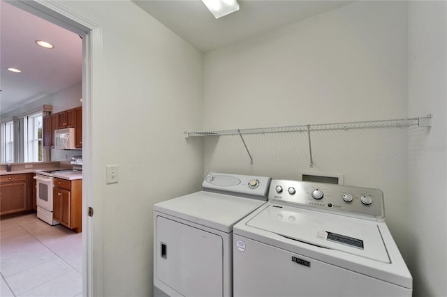 washroom featuring light tile patterned floors and washing machine and clothes dryer