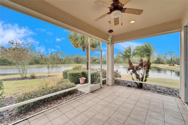 unfurnished sunroom with a water view and ceiling fan