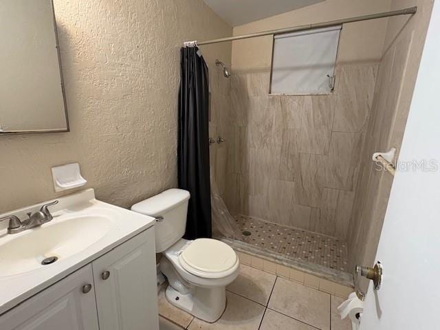 bathroom with toilet, tile patterned flooring, vanity, and curtained shower