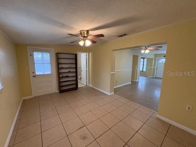 interior space featuring ceiling fan, a textured ceiling, and light tile patterned floors