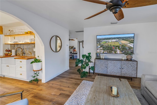 dining area featuring ceiling fan, sink, and hardwood / wood-style flooring