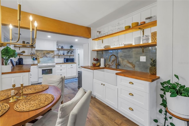 kitchen featuring wood counters, hardwood / wood-style flooring, white electric range oven, tasteful backsplash, and white cabinets