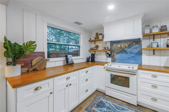 kitchen featuring wooden counters, decorative backsplash, electric stove, ornamental molding, and white cabinets