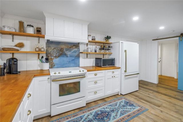 kitchen featuring white cabinets, butcher block countertops, white appliances, and light hardwood / wood-style flooring