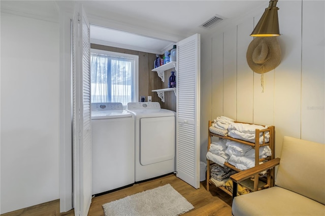 laundry room featuring washing machine and dryer and light wood-type flooring