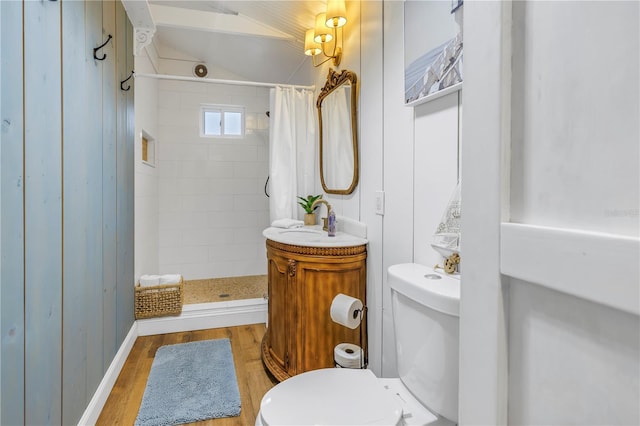 bathroom featuring toilet, lofted ceiling, a shower with curtain, and hardwood / wood-style floors