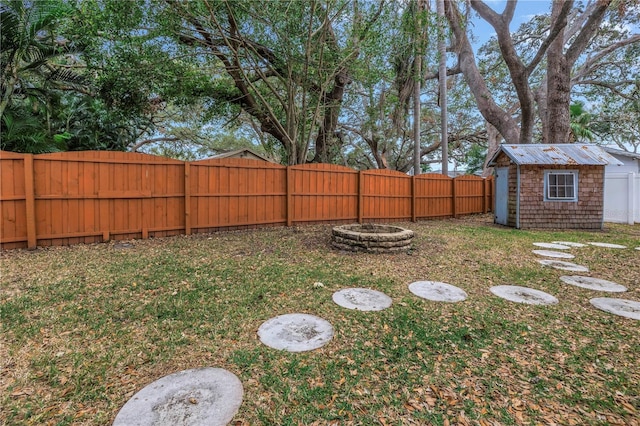 view of yard featuring a storage shed and a fire pit