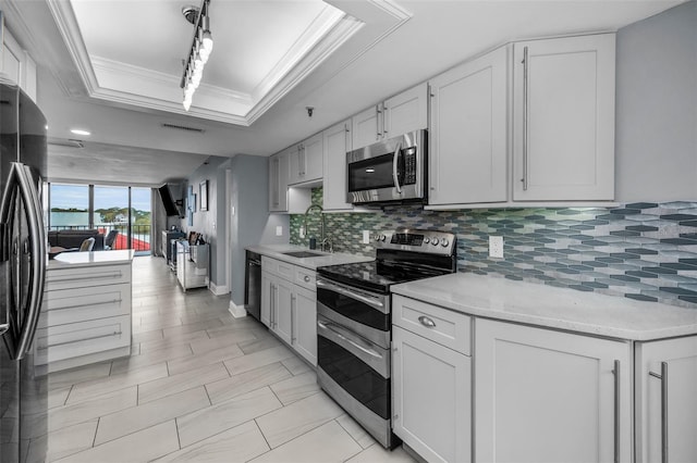 kitchen featuring white cabinetry, backsplash, ornamental molding, black appliances, and sink