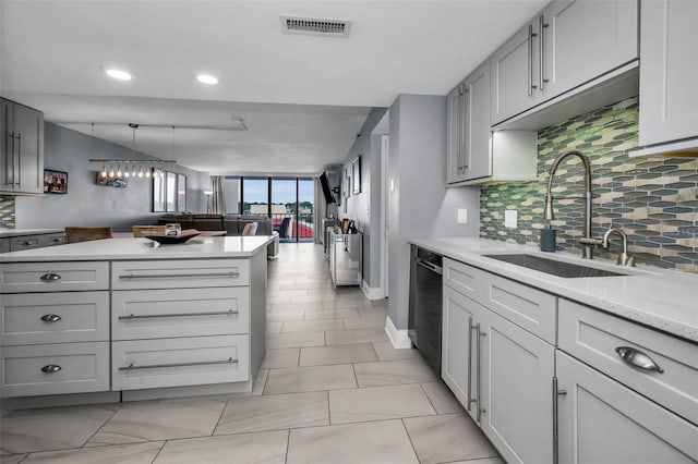 kitchen with gray cabinets, black dishwasher, backsplash, pendant lighting, and sink