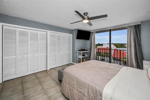 bedroom featuring access to outside, ceiling fan, multiple closets, and a textured ceiling