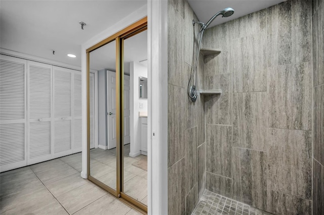 bathroom featuring vanity, tile patterned flooring, and tiled shower