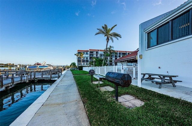 view of dock featuring a water view and a yard