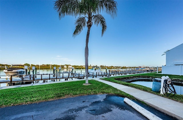 view of dock featuring a lawn and a water view