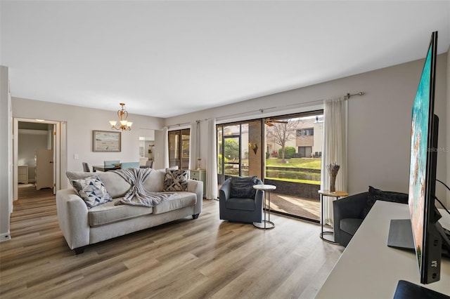 living room featuring a chandelier and light wood-type flooring