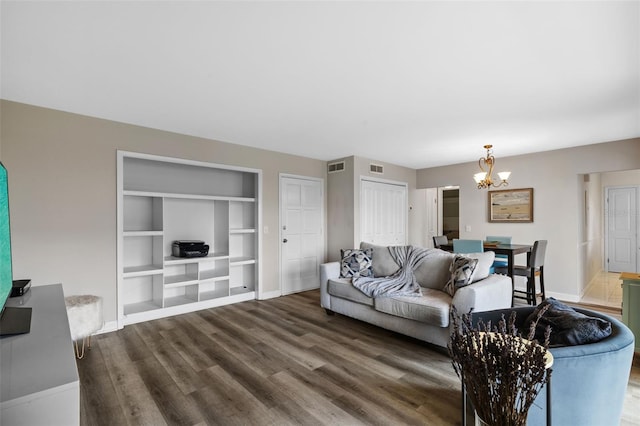 living room with an inviting chandelier, visible vents, baseboards, and dark wood finished floors