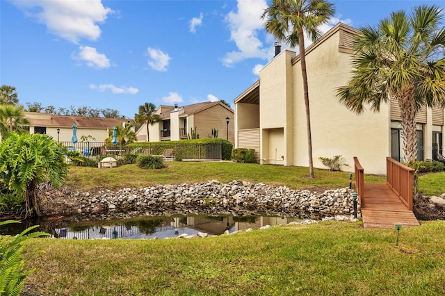 view of home's community with a yard and fence