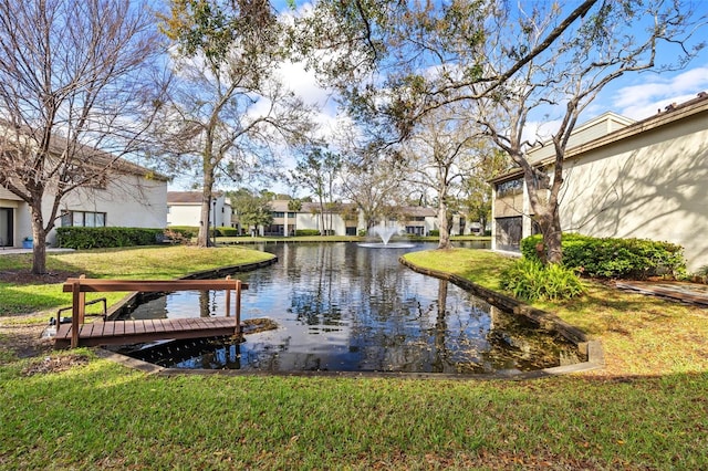 view of property's community with a yard and a water view