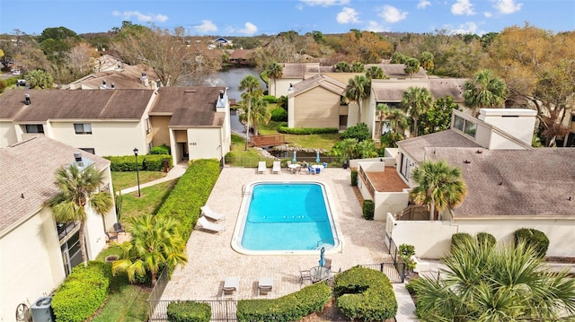 pool featuring a residential view, a patio area, a fenced backyard, and a gate