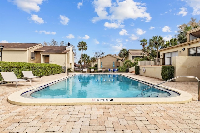 pool with a patio and fence