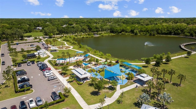 birds eye view of property with a water view and a wooded view