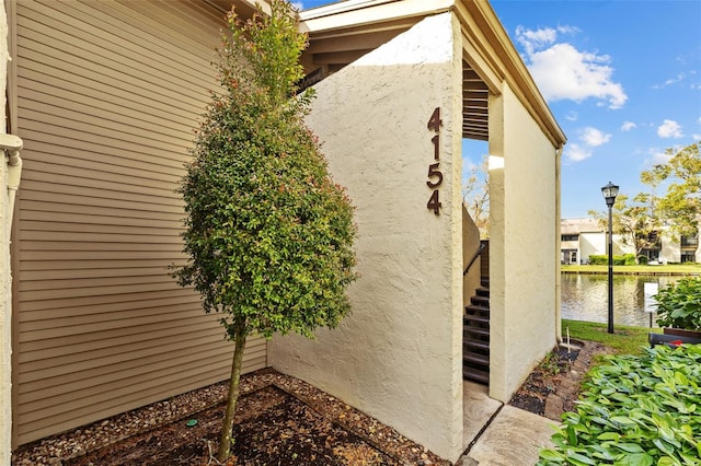 view of side of home featuring a water view and stucco siding