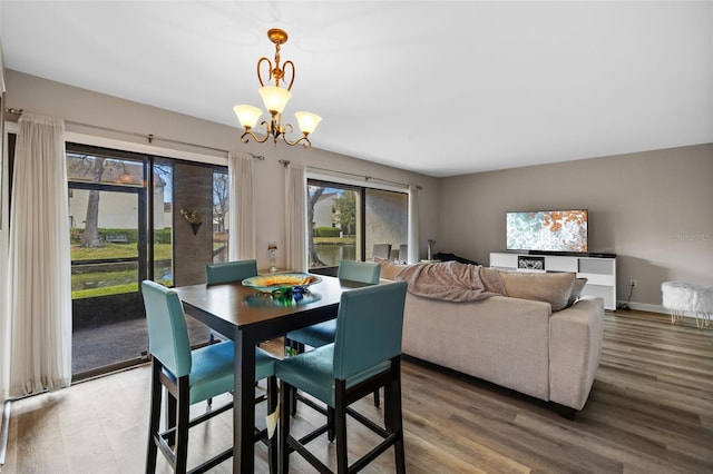 dining room with a chandelier, light wood-style flooring, and baseboards