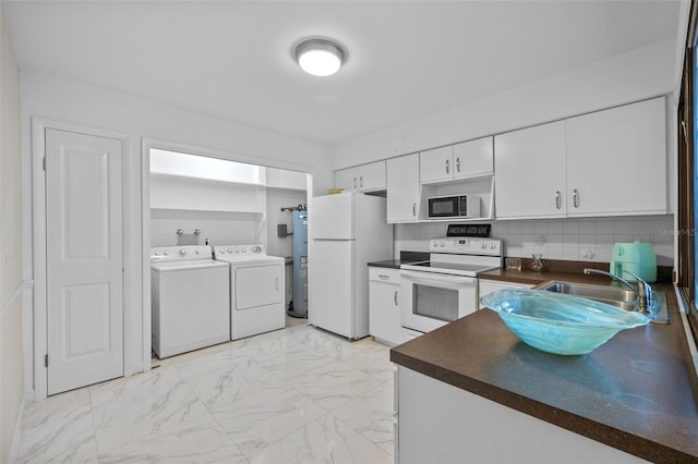 kitchen with dark countertops, white appliances, washing machine and dryer, and marble finish floor