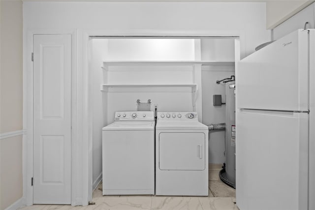 laundry room featuring electric water heater, marble finish floor, washing machine and dryer, and laundry area