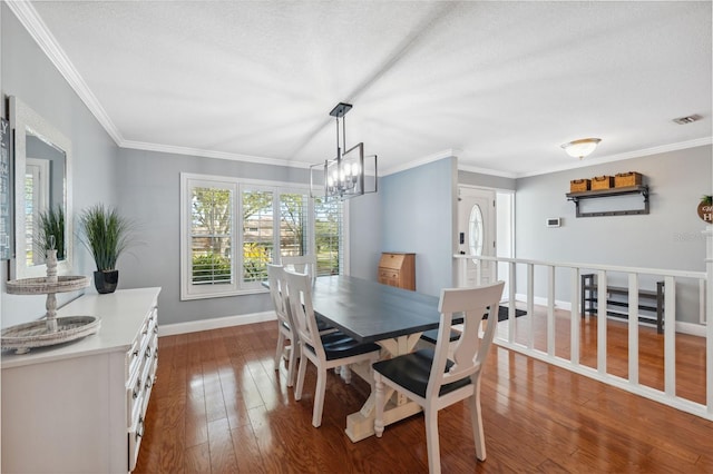 dining room featuring a textured ceiling, crown molding, and hardwood / wood-style floors