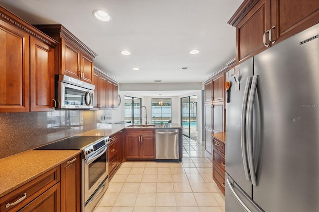 kitchen featuring kitchen peninsula, appliances with stainless steel finishes, tasteful backsplash, light tile patterned flooring, and sink