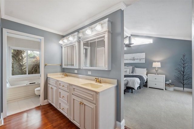 bathroom featuring toilet, hardwood / wood-style flooring, a tub to relax in, crown molding, and vanity