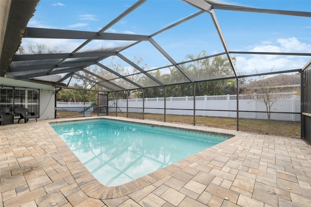 view of swimming pool with a patio area and a lanai