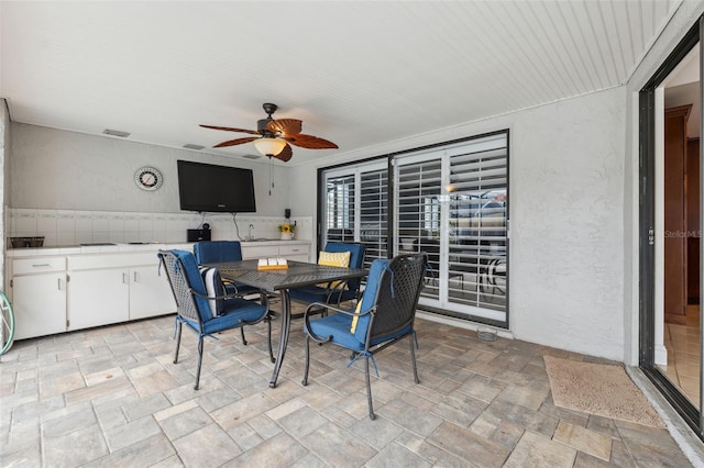 dining room featuring ceiling fan and sink