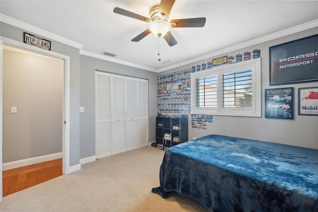 bedroom featuring ceiling fan, a closet, crown molding, and carpet floors